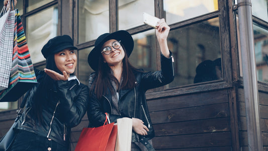 Two friends taking a selfie with shopping bags
