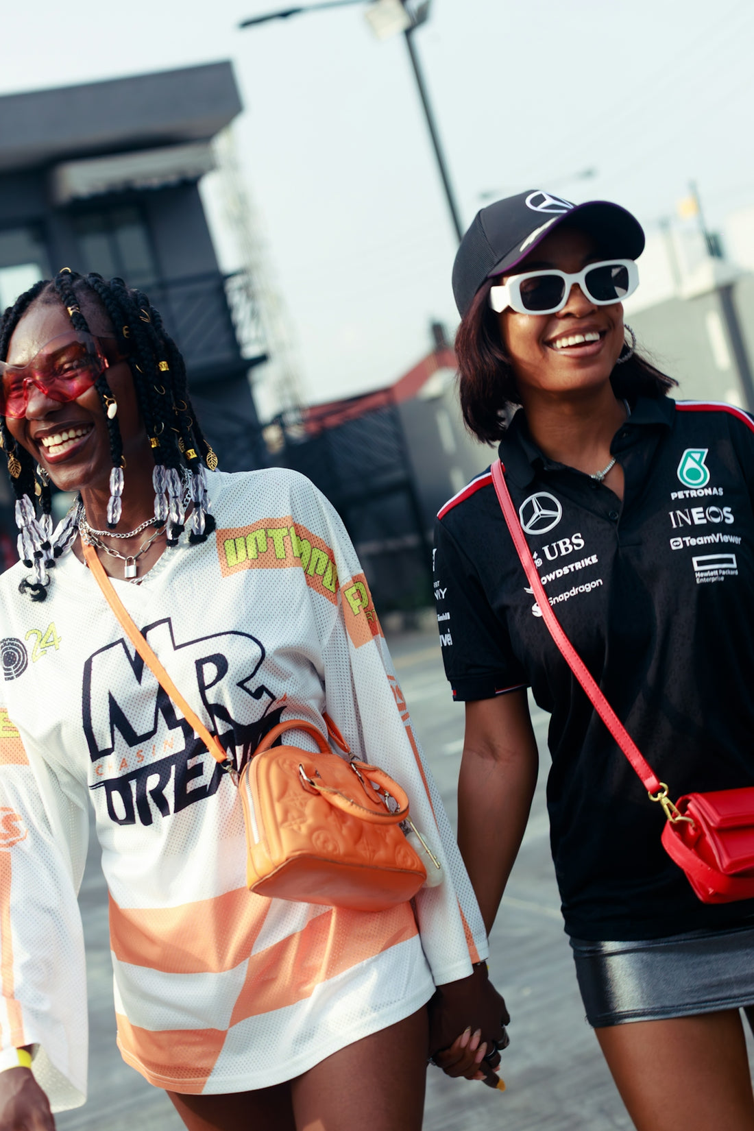Two smiling women holding hands outdoors